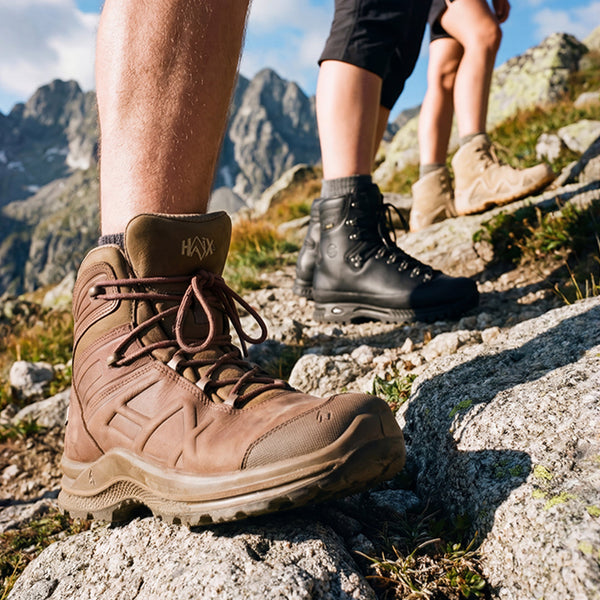 Drei Wanderer mit Bergstiefeln – braune, schwarze und beige Wanderschuhe – felsiges Berggelände beim Wandern in den Bergen